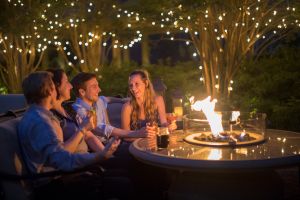 Couples socializing with drinks around fire pit